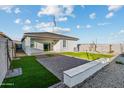 Paver patio and artificial turf creates a low-maintenance backyard, enclosed with block fencing for privacy at 24047 W Cocopah St, Buckeye, AZ 85326