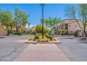 Gated community entrance with lush landscaping, palm trees, and manicured shrubbery at 2821 S Skyline Dr # 157, Mesa, AZ 85212
