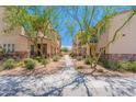 Beautifully landscaped walkway between townhomes, featuring lush greenery and mature trees at 2821 S Skyline Dr # 157, Mesa, AZ 85212