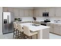 Modern kitchen featuring stainless steel appliances, a large island with a sink, and ample cabinet space at 2953 E Mecklenburg Way, San Tan Valley, AZ 85143