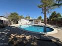 Sparkling private pool surrounded by mature trees and a fenced yard at 3933 E Flower St, Phoenix, AZ 85018