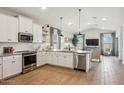 Beautiful kitchen featuring white cabinets, stainless steel appliances and island with pendant lighting at 42440 W Peters Dr, Maricopa, AZ 85138