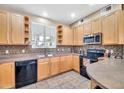 Cozy kitchen with wooden cabinets, a black appliance suite and ample counter space at 450 W Mountain Sage Dr, Phoenix, AZ 85045