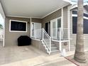 Inviting covered porch with white railings leading to the front door of this manufactured home at 591 S Ironstone Dr, Apache Junction, AZ 85119