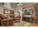 Cozy living room with stylish decor, including a leather sofa, area rug, and entertainment center for comfortable living at 6900 E Princess Dr # 1176, Phoenix, AZ 85054