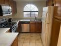 Kitchen featuring a window, wooden cabinets, stainless steel appliances, and tiled flooring at 818 S Westwood -- # 233, Mesa, AZ 85210