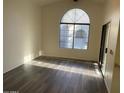 Living room featuring hardwood floors, a large arched window, and a sliding glass door at 818 S Westwood -- # 233, Mesa, AZ 85210