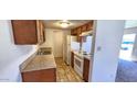 Cozy kitchen features wooden cabinets, neutral countertops, and white appliances at 948 S Alma School Rd # 71, Mesa, AZ 85210