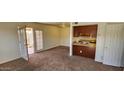 A sunlit room with neutral carpet adjacent to a patio with light entering through the glass doors at 948 S Alma School Rd # 71, Mesa, AZ 85210