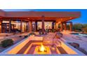 Captivating outdoor space featuring a modern fire pit, seating, and desert landscaping, perfect for evening relaxation at 10267 E Cinder Cone Trl, Scottsdale, AZ 85262