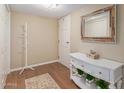 Bright entryway featuring wood floors, white console table, decorative mirror, and ample closet space at 10330 W Thunderbird Blvd # A301, Sun City, AZ 85351