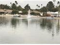 A tranquil waterfront view showcasing a fountain in the water and residential homes on the opposite shore at 10330 W Thunderbird Blvd # A301, Sun City, AZ 85351