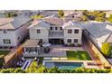 Aerial view of backyard oasis with pool, pergola with grill, patio seating and a manicured lawn at 10353 E Trillium Ave, Mesa, AZ 85212