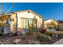Landscaped yard with flowering plants in front of a light-colored home with a stone-accented facade at 11385 N Luckenbach St, Surprise, AZ 85388