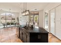 Bright kitchen with a black countertop island, stainless steel appliances, and access to the patio at 11490 E Beck Ln, Scottsdale, AZ 85255