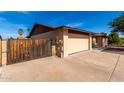 View of house and driveway, highlighting the ample parking and secure wooden gate at 12241 N 49Th Ave, Glendale, AZ 85304