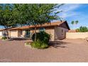 Lovely home exterior showcasing a lush, mature tree in the front yard and neutral earth-toned facade at 12241 N 49Th Ave, Glendale, AZ 85304