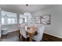Bright dining room featuring modern chandelier, wood table with cushioned chairs, and hardwood floors at 1383 E Prescott Pl, Chandler, AZ 85249