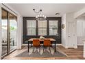 Modern dining area with stylish lighting, wood floors, and access to the backyard at 15488 W Aster Dr, Surprise, AZ 85379