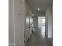 Bright hallway features tile floors, neutral paint, and access to other rooms in the home at 17481 W Fulton St, Goodyear, AZ 85338