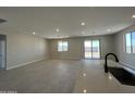 Open-concept living area with tile flooring and plenty of natural light from sliding glass doors at 17505 W Fulton St, Goodyear, AZ 85338