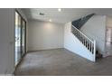 Open-concept living area with tile flooring, sliding glass doors, and access to the staircase at 17511 W Fulton St, Goodyear, AZ 85338