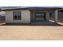 View of the back of the house with an outdoor covered patio and large sliding glass doors at 18168 W Larkspur Dr, Goodyear, AZ 85338
