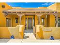 Charming front entrance with tiled roof, wooden columns, and decorative accents at 19834 W Minnezona Ave, Litchfield Park, AZ 85340