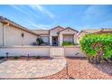 Low-walled front patio with seating area and decorative pavers, accessed through a metal gate at 20215 N Mariposa Way, Surprise, AZ 85374