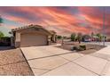 A single-story home featuring a desert landscape, two-car garage, and a long driveway at 2343 E Morelos St, Chandler, AZ 85225