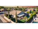 Aerial view of a private backyard with a covered patio, a well-maintained lawn, and a sparkling blue pool at 2343 E Morelos St, Chandler, AZ 85225