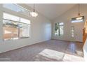Bright living room with vaulted ceilings, carpet, tile entryway, and multiple large windows at 2421 W Indigo Dr, Chandler, AZ 85248