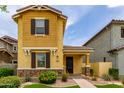 Inviting yellow home featuring a covered porch, meticulous landscaping, and great curb appeal at 2499 S Entwistle St, Gilbert, AZ 85295