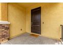 Covered front porch featuring a dark front door and a welcoming 'Hello' doormat at 2499 S Entwistle St, Gilbert, AZ 85295