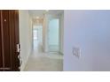 Bright hallway featuring neutral paint, tile flooring, and an open floor plan at 25137 W Wayland Dr, Buckeye, AZ 85326