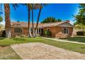 Inviting brick home boasts a terracotta tile roof, lush lawn, and mature shade trees at 28 E 14Th St, Tempe, AZ 85281