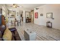 Bright living room featuring distressed floors, neutral walls, a ceiling fan, and comfortable furniture at 4117 E Molly Ln, Cave Creek, AZ 85331