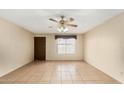 Inviting living room with a large window, tile floors, and a ceiling fan at 4219 W Pasadena Ave, Phoenix, AZ 85019
