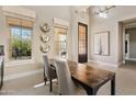 Bright dining area with tall ceilings, modern lighting, and picturesque backyard views through large windows at 5420 E Duane Ln, Cave Creek, AZ 85331