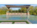 Stunning backyard pool features a beautiful pergola with planters and tranquil waterfall features for relaxation at 5420 E Duane Ln, Cave Creek, AZ 85331
