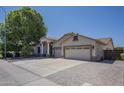 Wide shot of the home featuring a three-car garage and desert landscaping at 797 E Cedar Dr, Chandler, AZ 85249