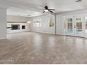 Bright living room featuring tile flooring, a fireplace, and glass doors leading to the outdoor pool area at 8301 E Indianola Ave, Scottsdale, AZ 85251