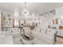 Bright living room with white sofas, chairs, a decorative rug, and a statement chandelier at 84 E Joseph Way, Gilbert, AZ 85295