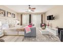 Cozy main bedroom featuring a plush bed, seating area, ceiling fan, and large windows at 84 E Joseph Way, Gilbert, AZ 85295