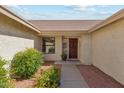 Inviting front entrance with decorative wooden door, well-kept landscaping, and a welcoming walkway at 9801 W Rockwood Dr, Peoria, AZ 85382
