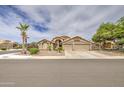 Spacious beige home with a manicured lawn and a three-car garage at 1217 S Longmore Ct, Chandler, AZ 85286