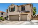 Side view of a two-story stucco home featuring a tiled roof and a two-car garage, all in a well-maintained neighborhood at 14129 W St Moritz Ln, Surprise, AZ 85379