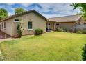 Spacious backyard with lush green lawn, mature landscaping, and a cozy patio area at 17765 W Ventura St, Surprise, AZ 85388