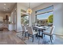 Elegant dining room featuring stylish decor, a modern chandelier, and large windows with outdoor views at 19608 N Regents Park Dr, Surprise, AZ 85387