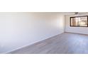 Spacious living room with new light-colored flooring, a ceiling fan, and a bright window view at 2440 N 22Nd Ave, Phoenix, AZ 85009